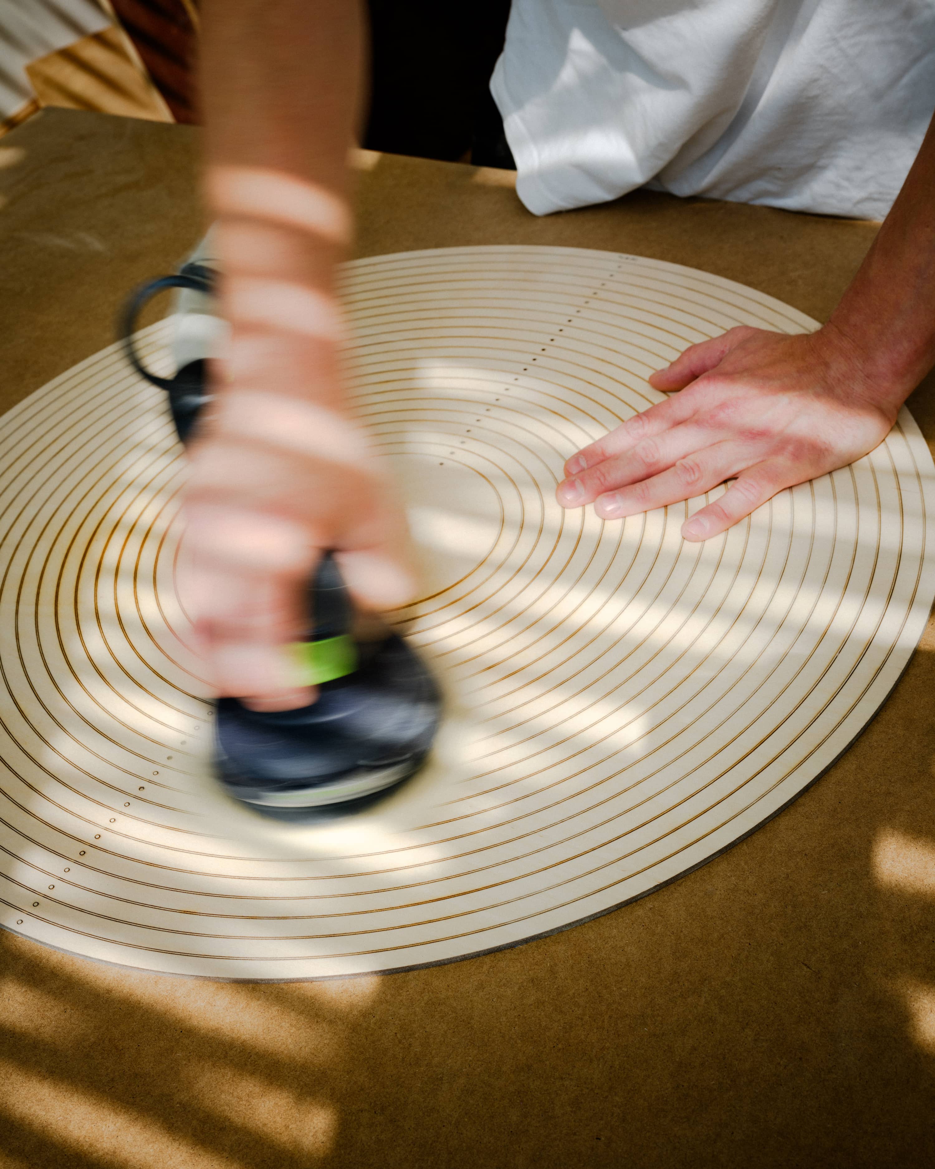 Koje-Studio-worker-produces-wooden-Cycloop-using-sandpaper-machine-in-Finland