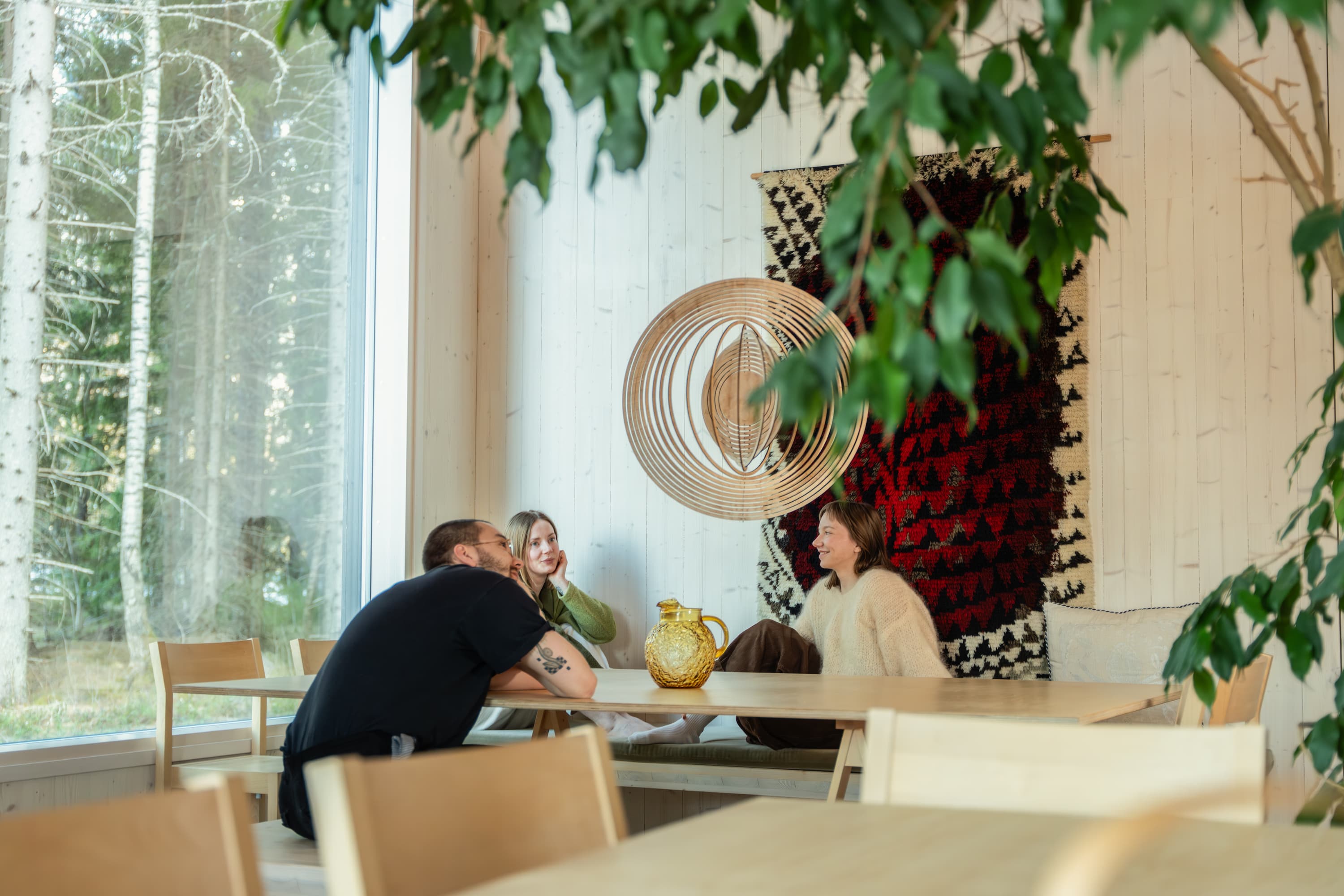 Young company is calm and feeling well observing Cycloop in a living room with plants, natural design and beautiful view from the window
